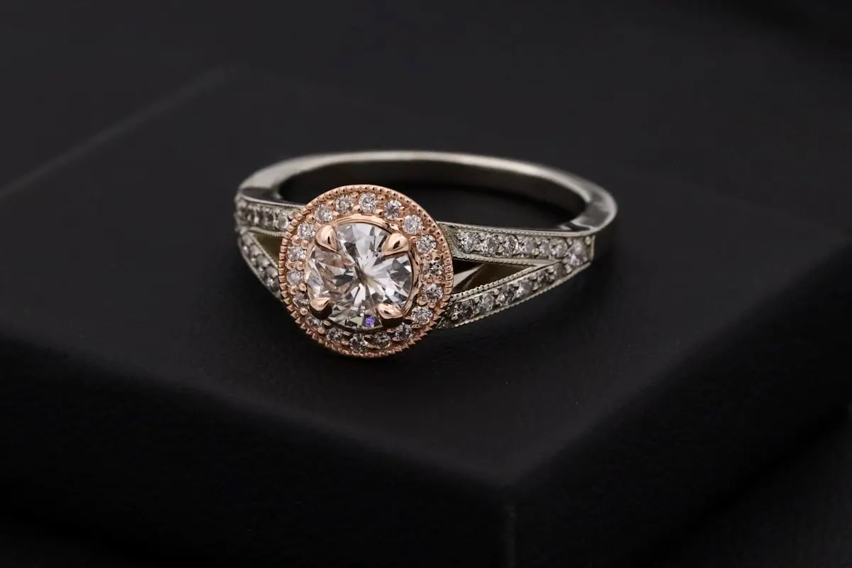 A close-up view of a sparkling, brilliant-cut diamond resting on an elegant gold jewelry setting, showcasing fine craftsmanship